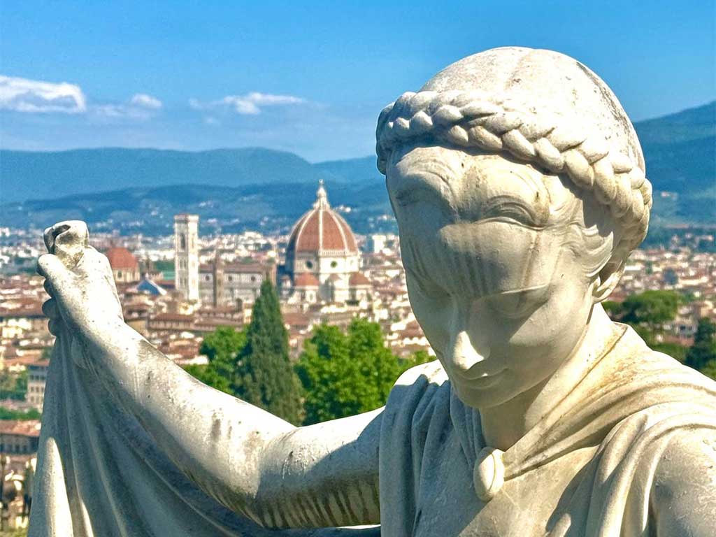 Close-up of a statue in Bardini Gardens with Florence Cathedral and the city skyline in the background