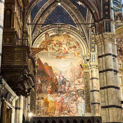 Interior fresco of Siena Cathedral depicting biblical scenes with vivid Renaissance colors and ornate Gothic arches