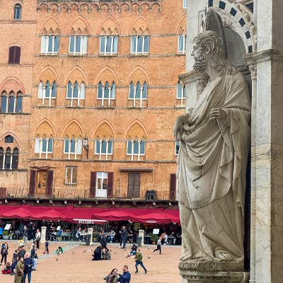 Marble statue overlooking Piazza del Campo in Siena, a highlight of a Siena day trip from Florence.