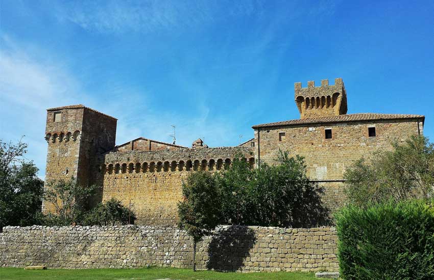 Medieval stone castle walls in Pienza under a clear blue sky in Tuscany, Italy