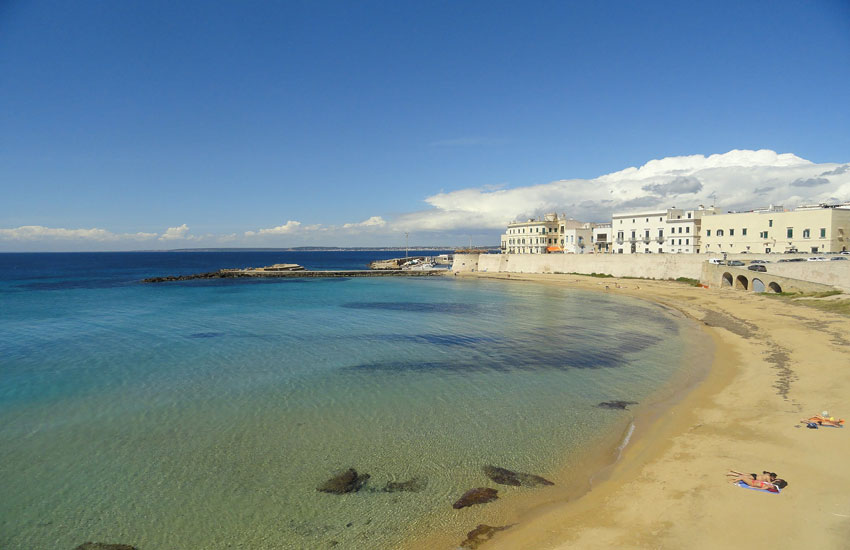 Gallipoli beach in Puglia, Italy, with turquoise water and historic old town walls in summer